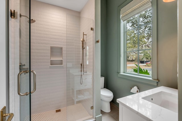 bathroom with vanity, tile patterned floors, a shower with door, and toilet