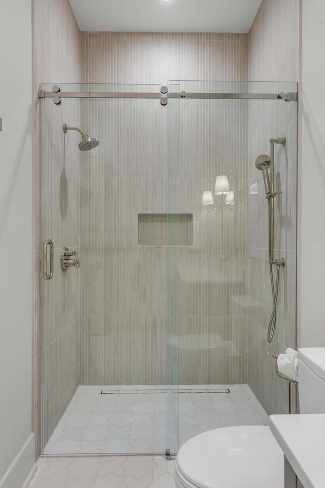 bathroom featuring vanity, toilet, and an enclosed shower