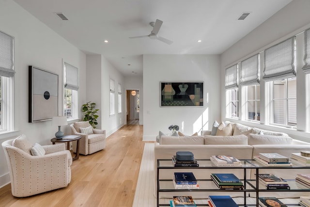 living room featuring light hardwood / wood-style flooring and ceiling fan