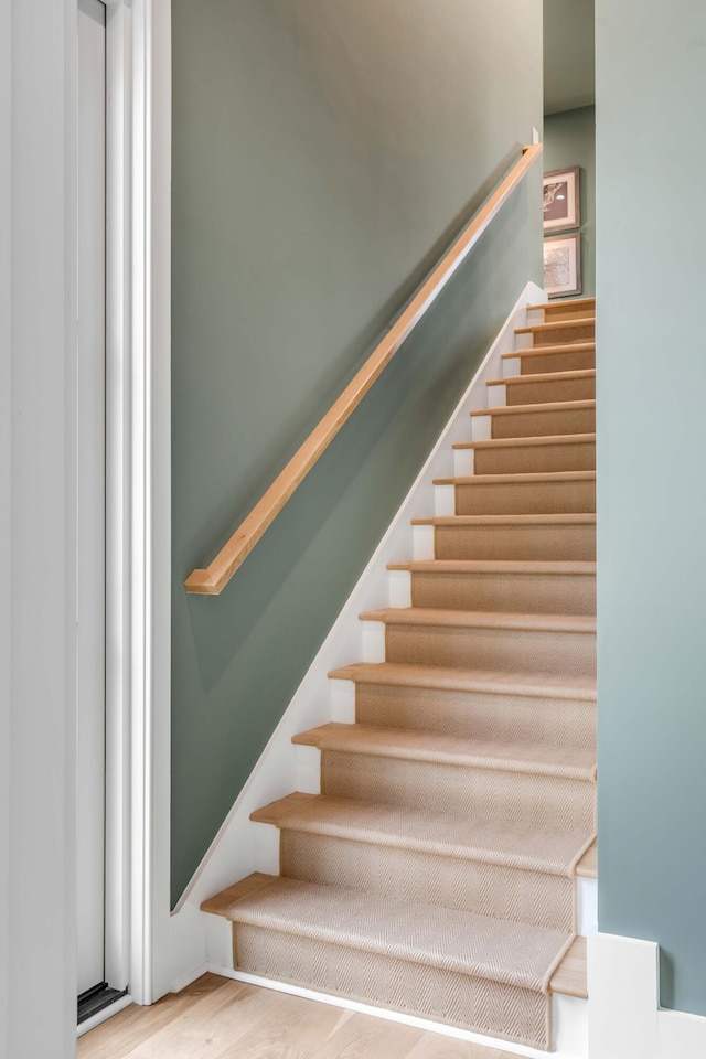 stairs featuring wood-type flooring