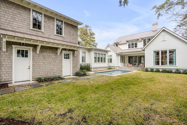 rear view of property featuring a lawn