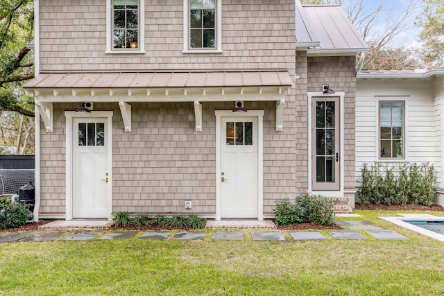 view of exterior entry with a yard