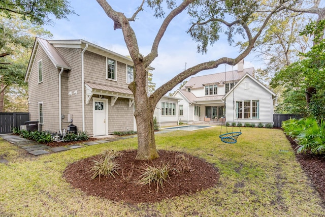 back of house featuring a fenced in pool and a lawn