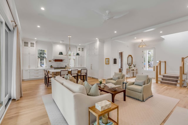 living room with ceiling fan and light hardwood / wood-style flooring