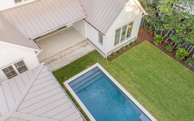 view of pool with a lawn