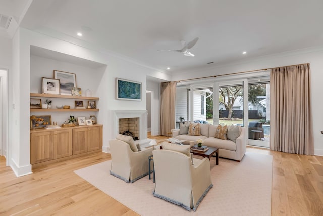 living room featuring crown molding, ceiling fan, and light wood-type flooring