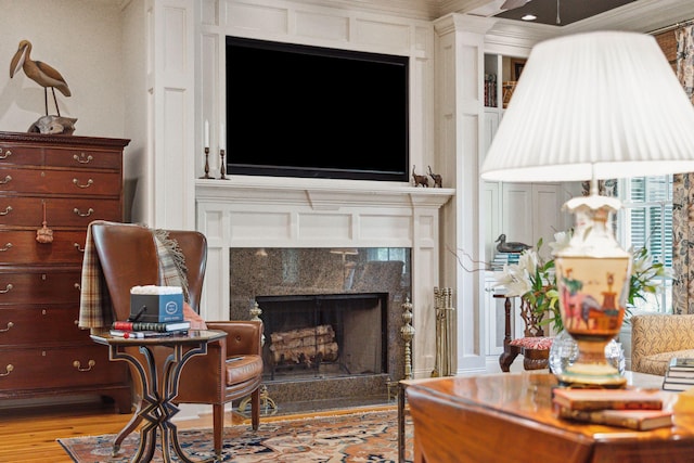 sitting room with a fireplace and wood finished floors