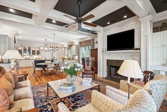 living area featuring beam ceiling, coffered ceiling, crown molding, and wood finished floors