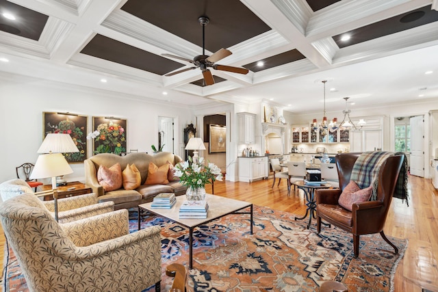 living room with coffered ceiling, ornamental molding, beamed ceiling, light wood-style floors, and ceiling fan with notable chandelier