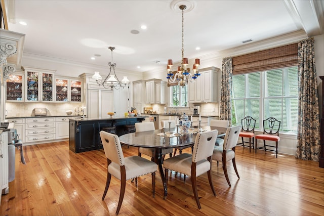 dining room with light wood finished floors, ornamental molding, a notable chandelier, and recessed lighting