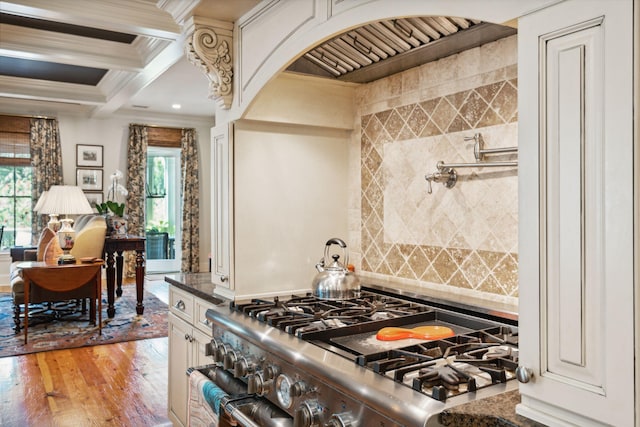 kitchen featuring decorative backsplash, ornamental molding, light wood-type flooring, beamed ceiling, and high end range