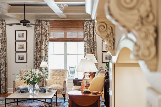 living area featuring ceiling fan, coffered ceiling, crown molding, and beamed ceiling