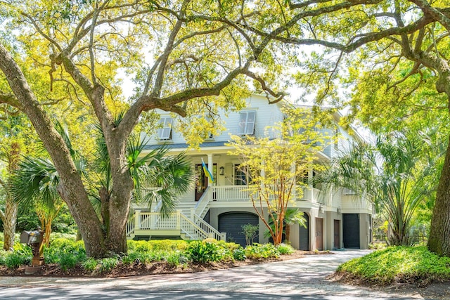 view of front facade with driveway, stairway, and a porch