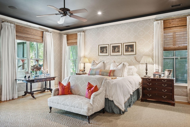 bedroom with carpet, visible vents, ornamental molding, a ceiling fan, and wallpapered walls