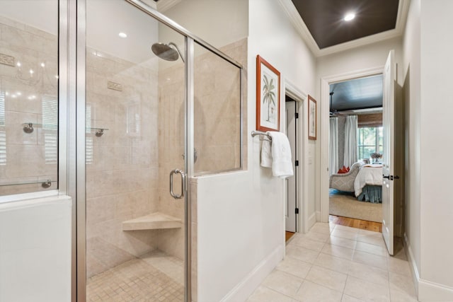 ensuite bathroom with baseboards, ornamental molding, tile patterned floors, a stall shower, and ensuite bath