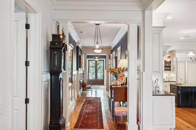 corridor featuring light wood-style flooring and crown molding