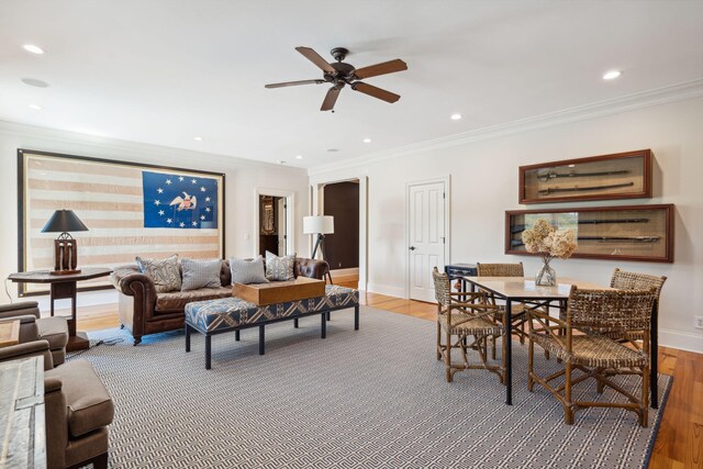 living room featuring baseboards, ornamental molding, wood finished floors, and recessed lighting