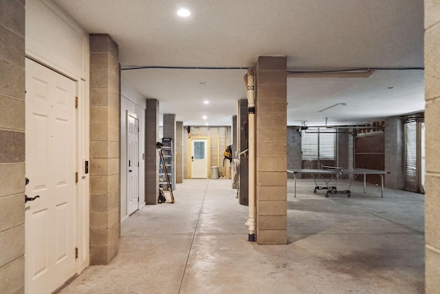 hall with recessed lighting and unfinished concrete floors