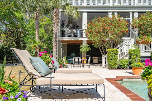 view of patio with stairs, outdoor dining space, and a balcony