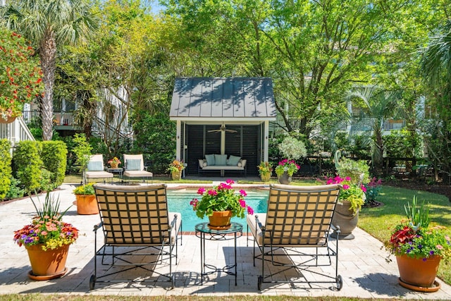 view of patio with an outbuilding, an exterior structure, an outdoor living space, and an outdoor pool