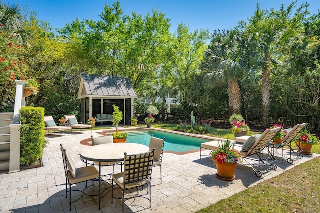 outdoor pool featuring a storage structure, a patio, and an outdoor structure