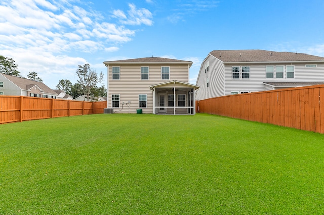 back of property with a yard, a sunroom, and central air condition unit