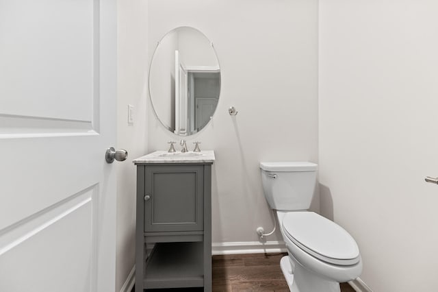 bathroom with hardwood / wood-style flooring, vanity, and toilet