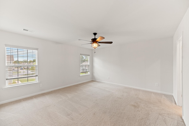 carpeted empty room featuring ceiling fan and a healthy amount of sunlight