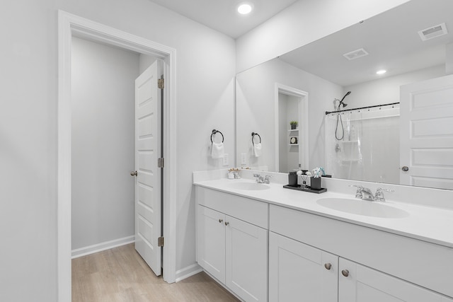 full bath with a shower with curtain, visible vents, a sink, and wood finished floors