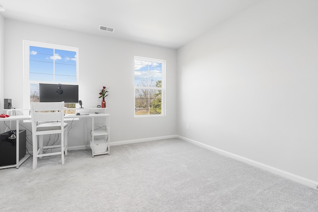 carpeted office space with baseboards and visible vents