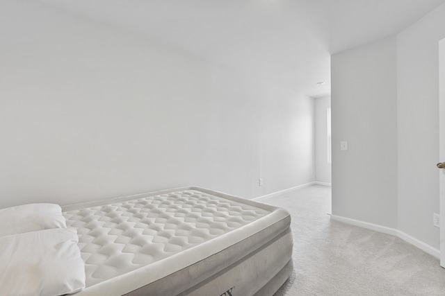 bedroom with light carpet and baseboards