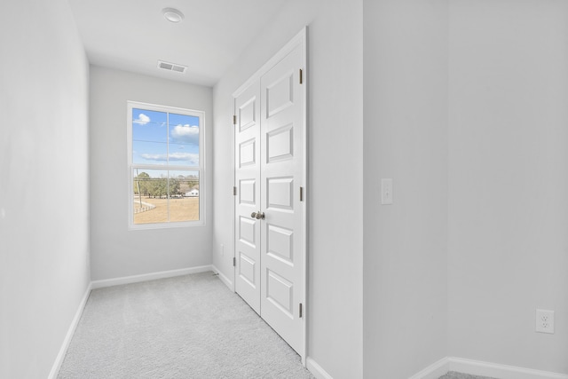 entryway with light carpet, baseboards, and visible vents