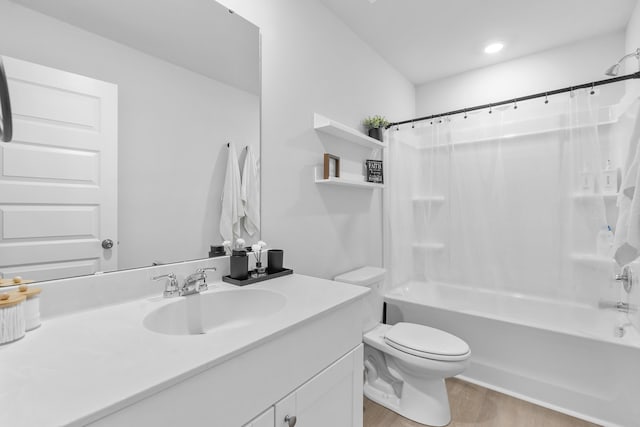 bathroom featuring toilet, shower / tub combo, wood finished floors, and vanity