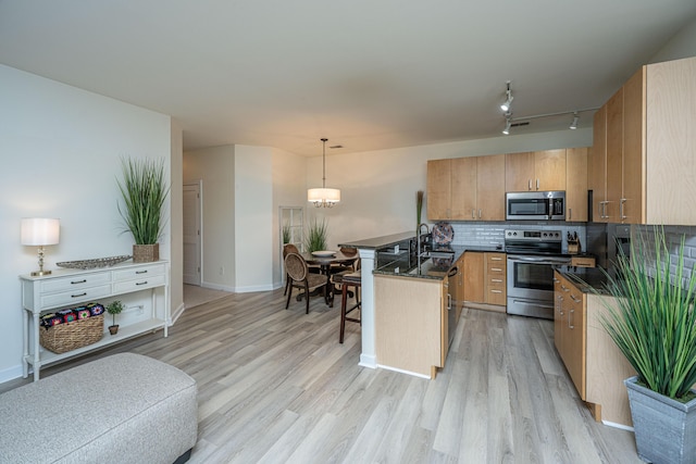 401 S Elgin Ct Unit 401, Charleston, SC 29414 - kitchen featuring appliances with stainless steel finishes, a breakfast bar, light wood finished floors, decorative backsplash, and a peninsula