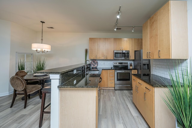 401 S Elgin Ct Unit 401, Charleston, SC 29414 - kitchen featuring stainless steel appliances, light wood finished floors, a peninsula, dark stone counters, and a breakfast bar