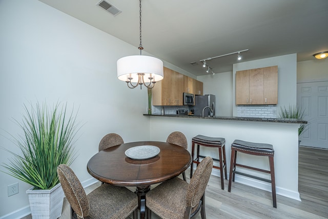 401 S Elgin Ct Unit 401, Charleston, SC 29414 - dining space featuring light wood-type flooring, baseboards, a chandelier, and rail lighting