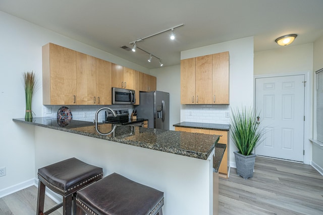 401 S Elgin Ct Unit 401, Charleston, SC 29414 - kitchen featuring appliances with stainless steel finishes, a peninsula, dark stone countertops, and tasteful backsplash