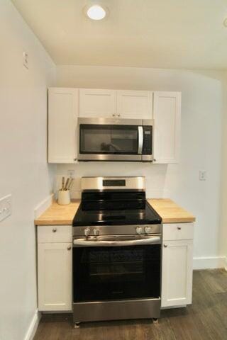 kitchen featuring butcher block counters, white cabinets, and appliances with stainless steel finishes