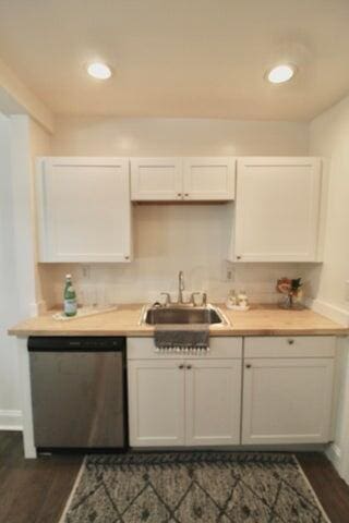 kitchen with stainless steel dishwasher, dark hardwood / wood-style floors, white cabinetry, and sink