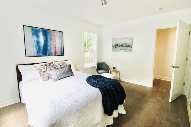 bedroom with dark hardwood / wood-style flooring