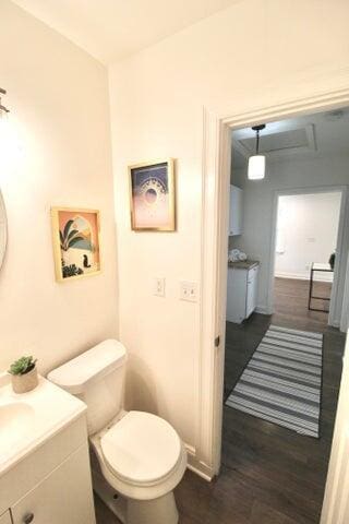 bathroom with toilet, vanity, and hardwood / wood-style flooring