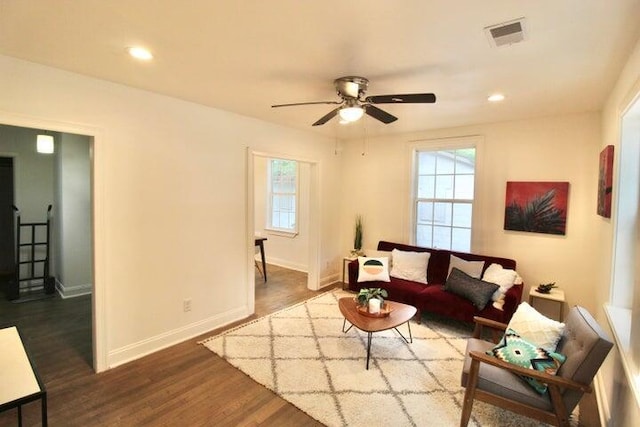 living room with dark hardwood / wood-style flooring and ceiling fan