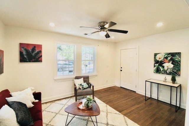 living area featuring ceiling fan and dark wood-type flooring