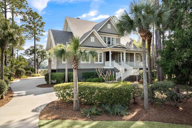 view of front of home featuring concrete driveway, stairway, and covered porch