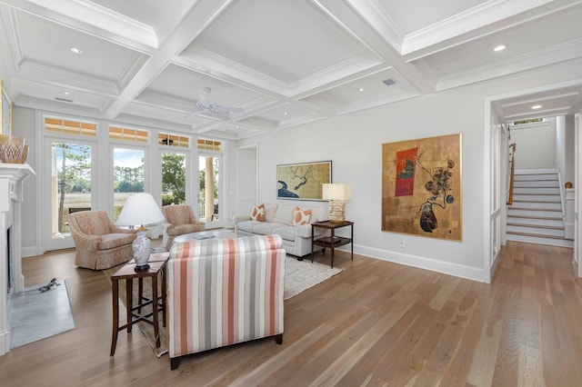 living room with beamed ceiling, coffered ceiling, light wood-style flooring, and a fireplace