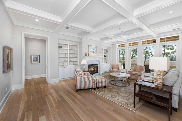 living area featuring plenty of natural light, coffered ceiling, and beam ceiling