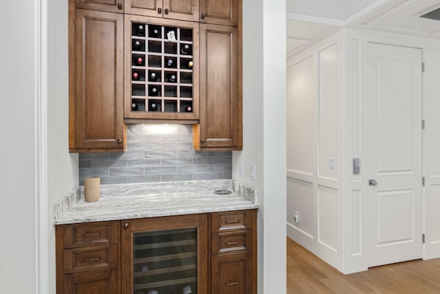 bar with visible vents, beverage cooler, tasteful backsplash, light wood-style floors, and a bar