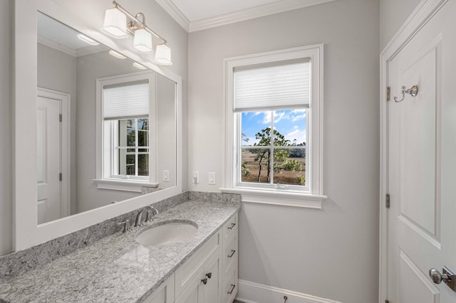 bathroom featuring vanity, crown molding, and baseboards