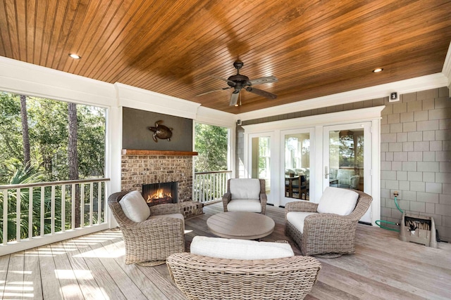 sunroom with a ceiling fan, wood ceiling, and an outdoor brick fireplace