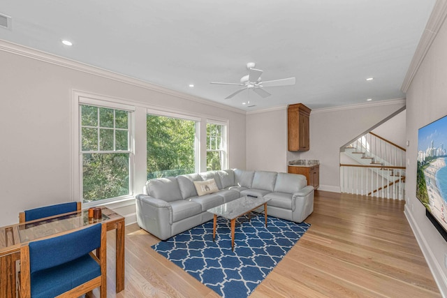 living area featuring wood finished floors, visible vents, baseboards, ornamental molding, and stairs